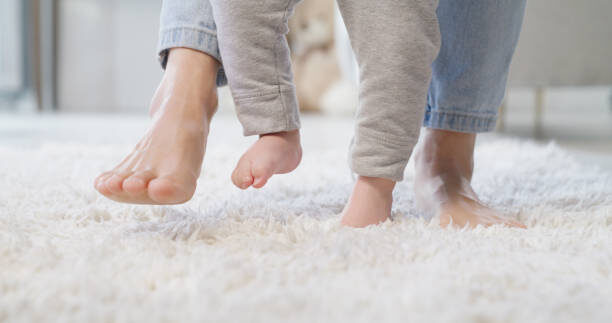 Baby and mom feet on carpet